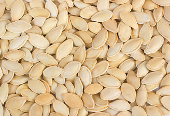 Pumpkin seeds background. Top view with many raw seeds of pumpkin.