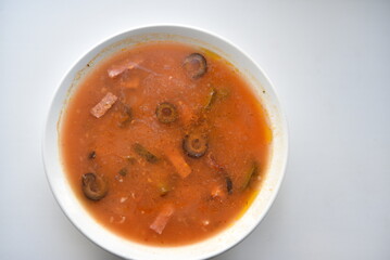 Soup with sausage in a plate. Meat solyanka. Delicious soup.