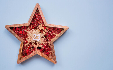 Greeting card for the Defender of the Fatherland Day. White, gold, red stars and the number 23 on a light blue background. The holiday is February 23.