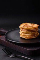 Delicious fresh pancakes with berry jam on a black ceramic plate