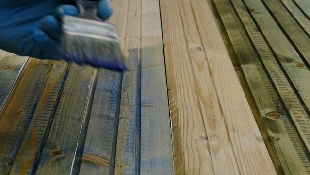 man priming paints boards with a paint brush time lapse