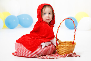 Little girl dressed as a red riding hood on white background. Carnival, Purim, Halloween
