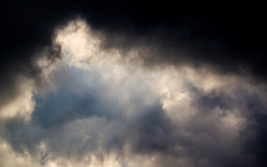 The sun rays break through dark thunder clouds