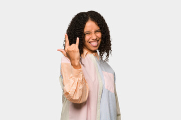 Fototapeta na wymiar Young african american curly woman isolated showing rock gesture with fingers