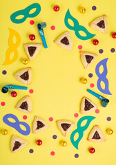 Hamantaschen Cookies, Carnival Mask, Noisemaker on Yellow Background. Purim Celebration, Jewish...