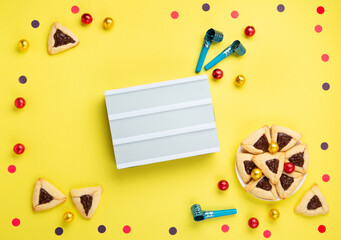 Hamantaschen Cookies, Carnival Mask, Noisemaker on Yellow Background. Purim Celebration, Jewish...