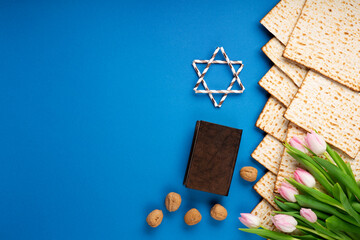 Passover Greeting Card with Mfatzah, Nuts and Pink Tulip Flowers on Blue Background.