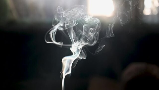 Cigarette smoke with black background. Wisp of cigarette smoke. Nicotine addiction. 