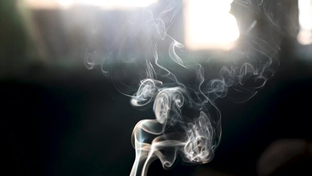 Slow motion of Cigarette smoke with black background. Wisp of cigarette smoke. Nicotine addiction.