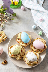 Obraz premium Easter composition. Sweet Italian Easter Bread Rings from puff pastry and dyed eggs on a stone background. Copy space.