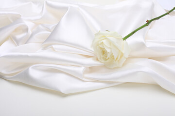 Nacre wave fabric silk with white rose flower bouquet. Abstract texture horizontal copy space...