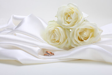 Nacre wave fabric silk with white rose flower bouquet and wedding ring.