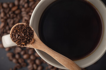 Abstract Coffee Background With Coffee Beans, Wooden Spoon, And Coffee Cup on a Black Background