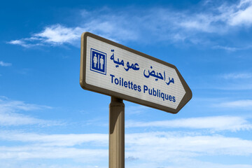Right pointing directional sign guiding towards public toilets and written in Arabic and French