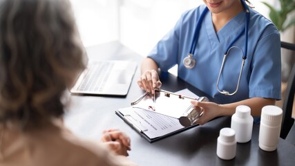 Young nursecaregiver advising contented senior woman on medication in the room. Medication for seniors, healthcare