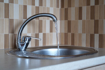 Water pours in a strong stream from tap in kitchen