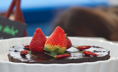 Chocolate cake with chilli and strawberries at the Naplavka farmers street food market on the waterfront of the Vltava River in Prague.