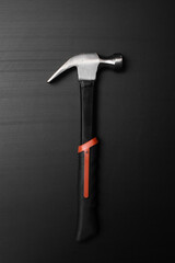 hammer with black and orange hand on black table