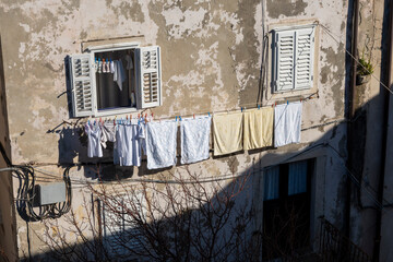 Clothes hanged on the rope drying in the gentle winter sun and wind on the house in old part of...