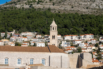 Fototapeta na wymiar Rosary Church of the Dominican Monastery, Dubrovnik, rising above red rooftops and city port
