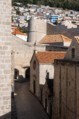 Fototapeta na wymiar Beautiful old, Dubrovnik city streets, encircled with medieval, stone walls and modern houses built on the hill slope above the city
