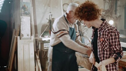 Grandfather and grandson dance in the workshop celebrating the success of making a new guitar by hand. Carpentry, craftsmanship and handwork concept