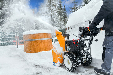 Clearing snow with a snowblower after snow fall.