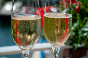 Drinking of French brut champagne sparkling wine in glasses in yacht harbour of Port Grimaud near Saint-Tropez, French Riviera vacation, France
