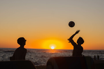 silhouette of a person with a ball at sunset