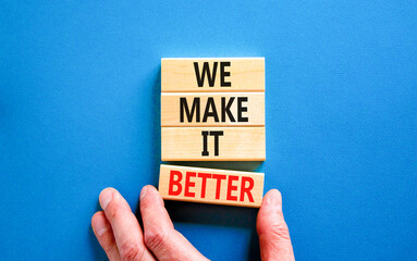 We make it better symbol. Concept words We make it better on wooden blocks. Beautiful blue table blue background. Businessman hand. Business we make it better concept. Copy space.