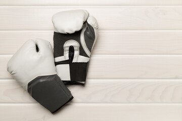 Martial arts gloves on wooden background, top view