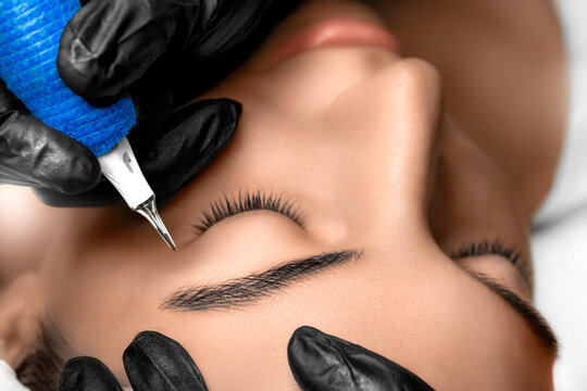 Permanent Makeup. Detail of beautiful woman eyebrow with nice black Brows In Beauty Salon.