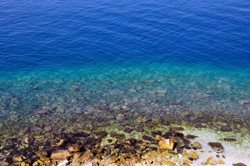Fototapeta na wymiar wonderfully blue rocky bottom with transparent water.