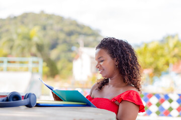 Black brazilian university student smiling and studying outside college.