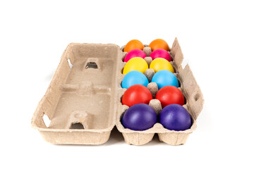 Brightly colored confetti eggs in a brown egg carton end view