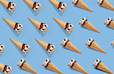 Pattern of hazelnut ice cream on a stick on blue pastel background