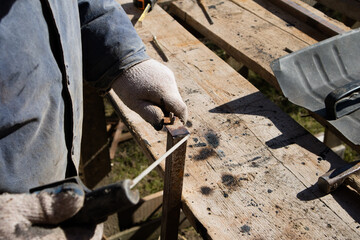 The man makes electric welding at home. Workshop at home. 
The master works in gloves in the village yard
