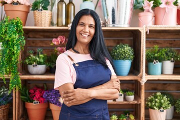 Middle age hispanic woman florist smiling confident standing with arms crossed gesture at florist - obrazy, fototapety, plakaty