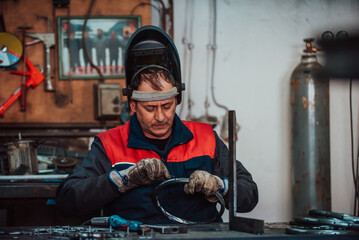 A worker in an industry preparing iron structures for welding