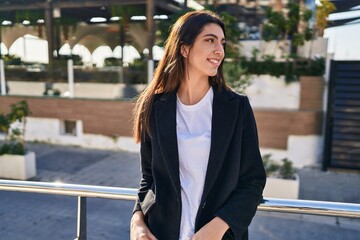 Young beautiful hispanic woman smiling confident looking to the side at street