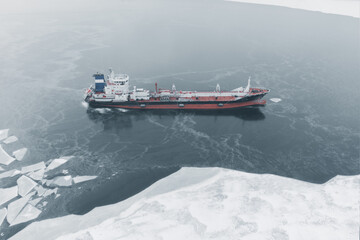 Oil tanker bound by young ice. Aerial view. Topic of supplies of petroleum products