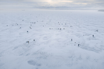 Fishermen on the ice of a frozen reservoir. Winter fishing theme