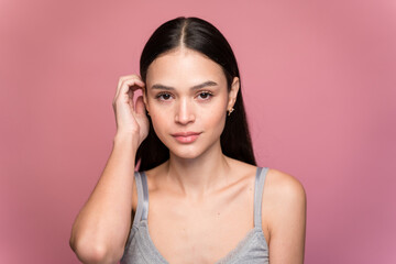 Young woman with makeup against pink background