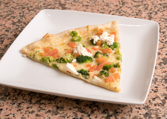 Slice of white pizza with broccoli and tomatoes 