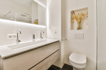 a modern bathroom with white walls and black flooring the sink is in front of the mirror on the wall