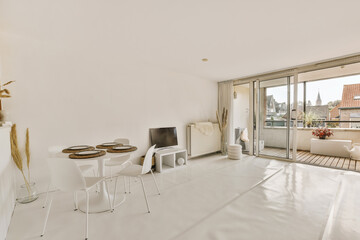 a living room with white furniture and large sliding glass doors that open onto the balcony...