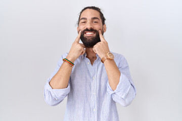 Hispanic man with beard wearing casual shirt smiling with open mouth, fingers pointing and forcing cheerful smile