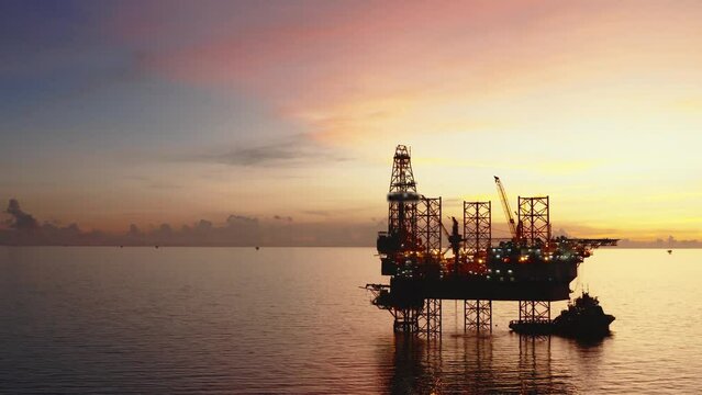 Jack up drilling rig and production platform in the middle of the ocean at sunrise time
