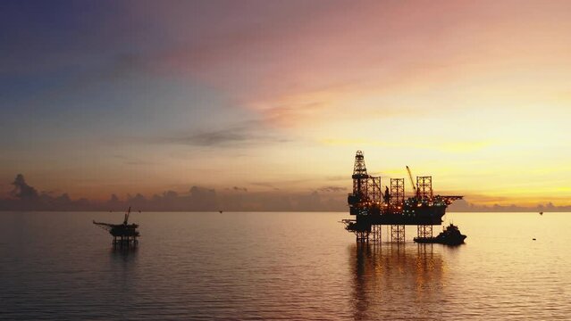 Jack up drilling rig and production platform in the middle of the ocean at sunrise time
