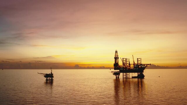 Jack up drilling rig and production platform in the middle of the ocean at sunrise time
